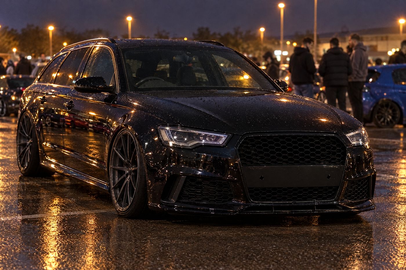Black estate at a wet night meet, running plate-free